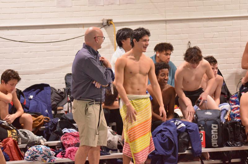 Sussex Academy coach Tom Martiner shares a laugh with Angel Figueroa shortly after the senior won the butterfly with a time of 59.78.