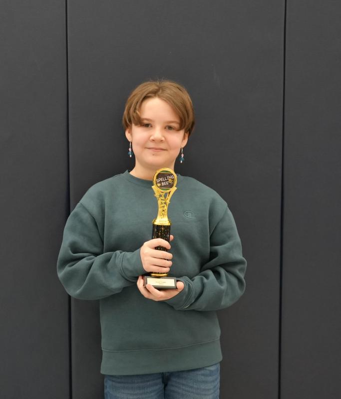 Cass Spinosa smiles with his Love Creek spelling bee trophy after winning the competition for the second consecutive year.