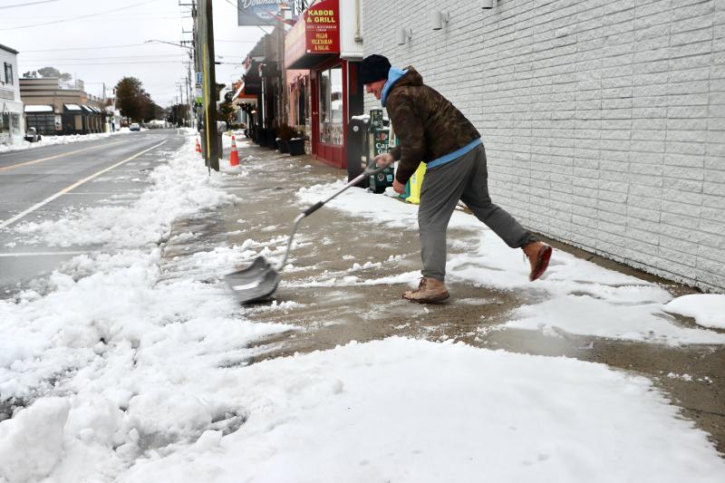 Grant Brown is hard at work clearing the sidewalk on First Street near Downtown Blues. BILL SHULL PHOTO