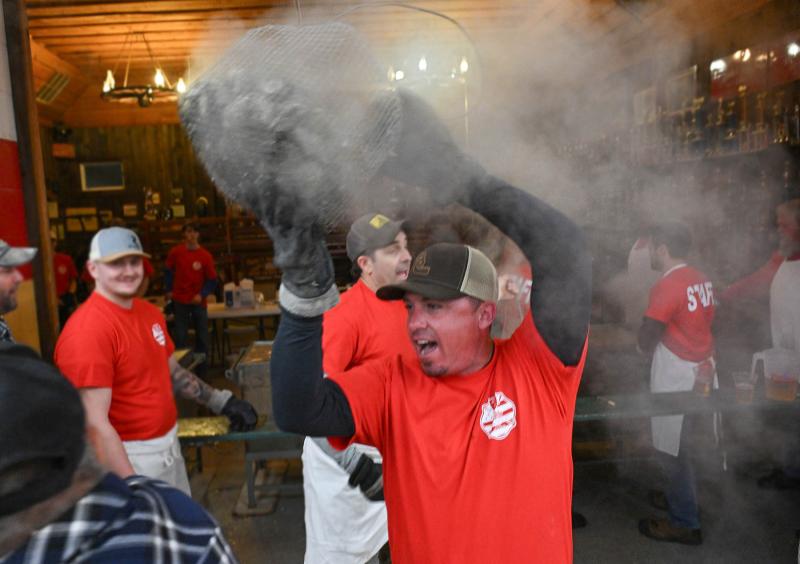 Jake Ricker, president of the Georgetown Fire Company, carries a basket of oysters to awaiting shuckers.