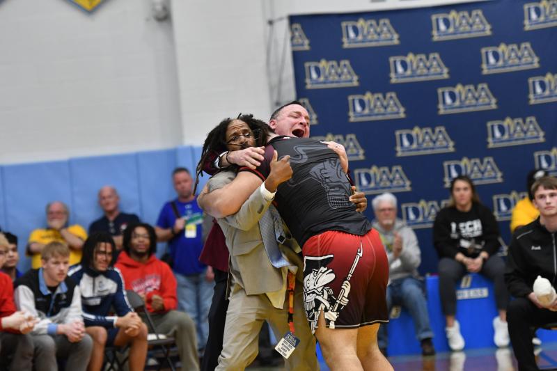 Eliedxander Jarquin-Torres of William Penn wins title at 285 and is embraced by his coaches Bijan Banks and Joe Archangelo.