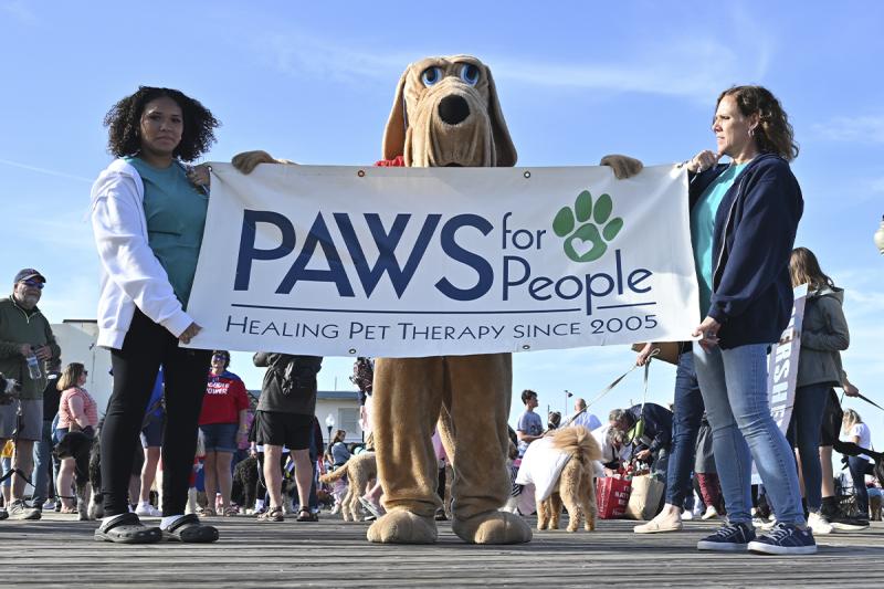 Jaca, 14, and Leslie Catta are joined by Delmar in holding the PAWS for People banner at the start of the parade.