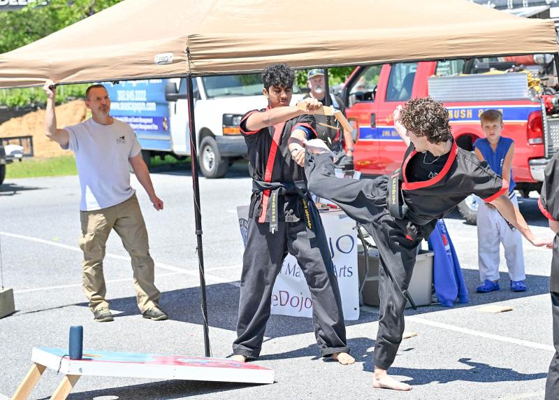 Ted Dabbs, left, owner of Seaside Dojo watches as his students Kavin Prattipati, center, and Graham Yeatman do a board-breaking demonstration.