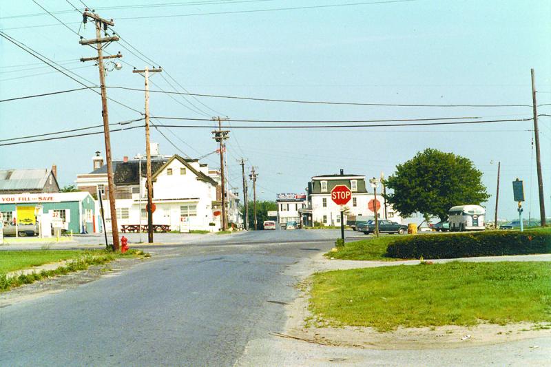 The intersection of Front Street and Savannah Road in Lewes in the early 1970s looking westward from Gills Neck Road. Today, Dogfish Inn stands just outside the frame to left, while the bike corral at the drawbridge is in the green area to the right. Lou Ianiere’s Restaurant can be seen in the distance on Front Street. PHOTO COURTESY OF LEWES HISTORICAL SOCIETY - GEORGE NOCITO COLLECTION