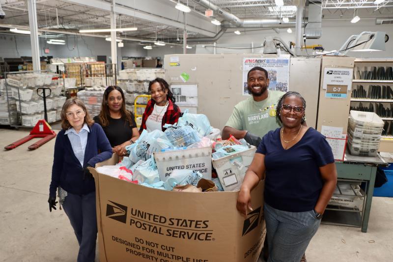 Employees at the U.S. Postal Service Rehoboth Beach Carrier Annex show off one of the bins of food that carriers collected during this year’s Stamp Out Hunger drive May 10. Local food banks come to the facility to pick up the donations. Shown are (l-r) Karen Layton, carrier; Felitcha McPherson, supervisor; Taniesha Kelley, supervisor; Andre Duncan, supervisor; and Dionne Watts, postmaster. BILL SHULL PHOTO