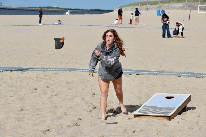 Marlise Harris plays cornhole with other lifeguards at their season kickoff party on Savannah Beach. Harris is one of nine rookies on the beach patrol this season.