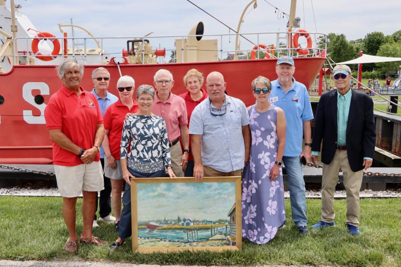 John Schroeder donated a painting of the Lewes canalfront done by his father Howard Schroeder to the Overfalls Foundation. Dave Shook, Overfalls president, said it will hang in their new museum that will soon be under construction across from the ship in Canalfront Park. Shown are (l-r) Dave Shook, Overfalls Foundation president; Ted Hack, board member; Patty Jackson, board member; Sue Schroeder, Carolyn Rogers’ daughter; John Schroeder, Carolyn Rogers’ son-in-law; Cindy Castellana, treasurer; Mark Rogers, Carolyn Rogers’ son; Paula Rogers, Carolyn Rogers’ daughter-in-law; Al Cybart, board member; and Brian North, board member. BILL SHULL PHOTO