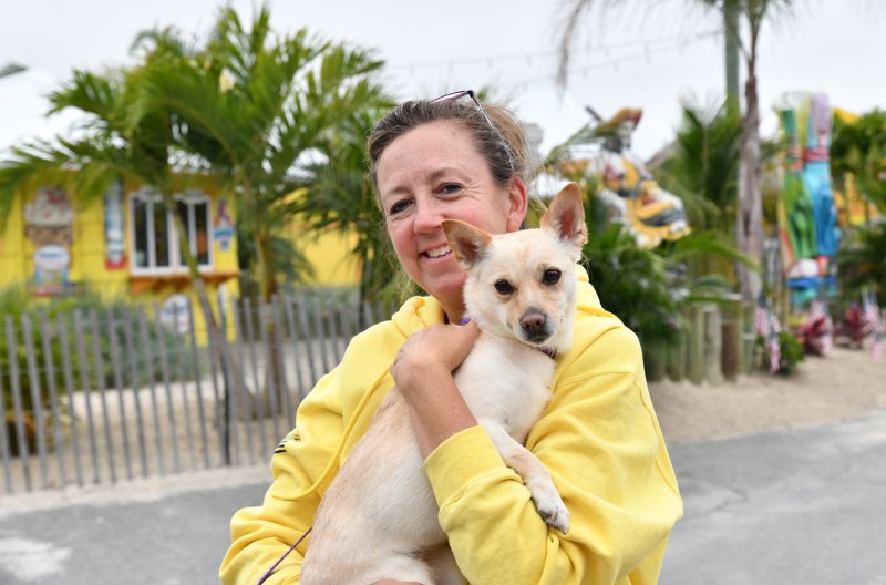Barbara Ann Racine-Kerezsi, event director for Paradise Companies, gets some love from Sandy Ana before she was adopted.