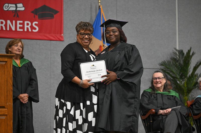 Anshainaye Jackson receives the Organization of Adult Alumni and Students in Service Scholarship from OAASIS Team Leader Chanteea Harmon.