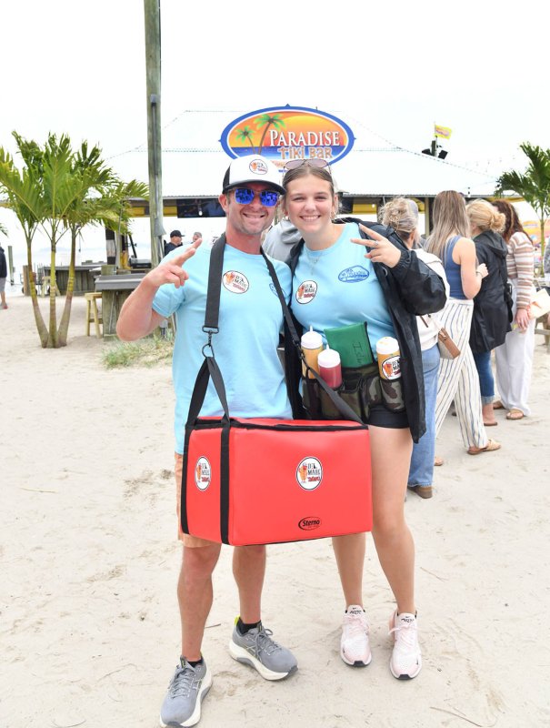 Bryan Sears, chief operating officer of Paradise Companies, left, and Chloe Gravatt sell hot dogs at the event with all proceeds going to Grass Roots Rescue.