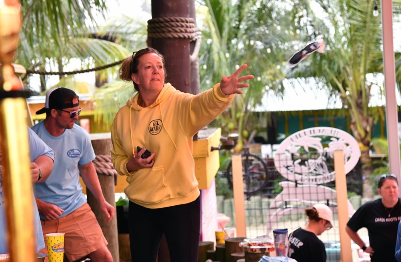 Barbara Ann Racine-Kerezsi, event director for Paradise Companies, tosses Del Made coozies to the crowd.
