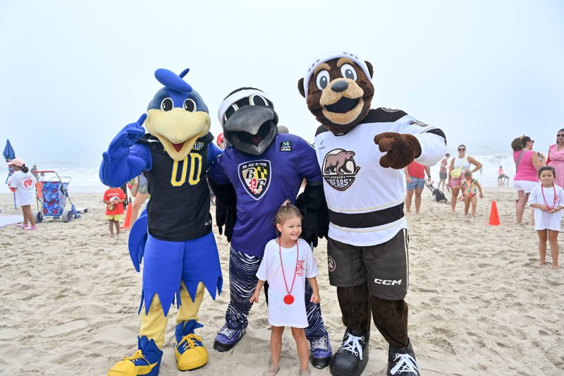 Josephine DiSabatino, 4, poses with her new friends (l-r) University of Delaware mascot YoUDee, Baltimore Ravens mascot Poe and Hershey Bears mascot Coco.