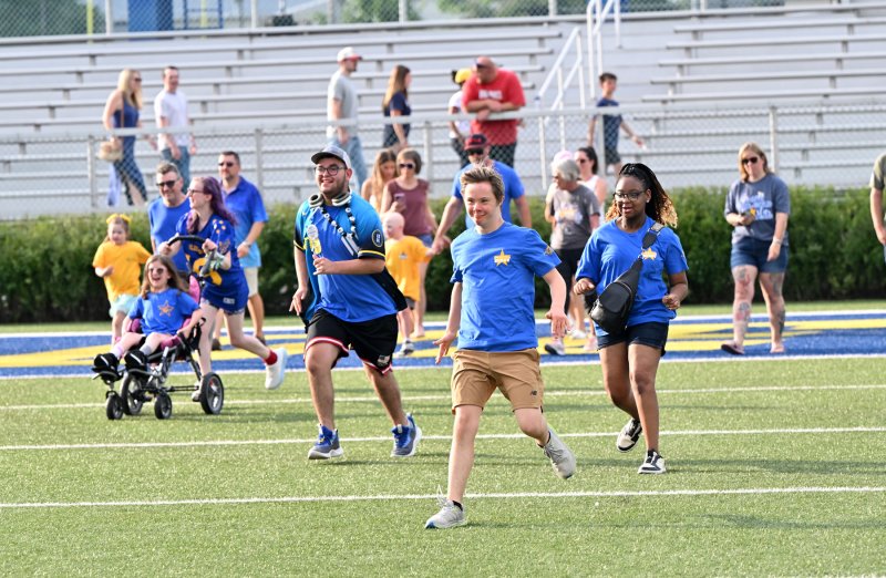 The buddies rush to their partners on Tubby Raymond Field before the DFRC Blue-Gold All-Star Football Game.