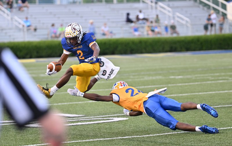 Gold defensive back Ji’Kare Banks (Woodbridge) makes shoe-sting tackle of Blue receiver Brysheem Davis of Hodgson.