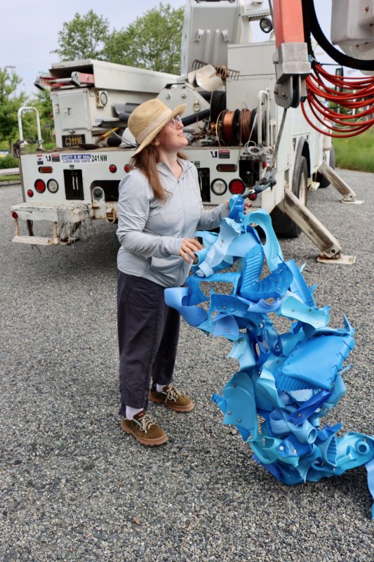 Niki Lederer holds the blue piece, which was attached to one of the trellises in Canalfront Park. She said she pulls all of the plastic bottles from curbside recycling in Brooklyn, N.Y.