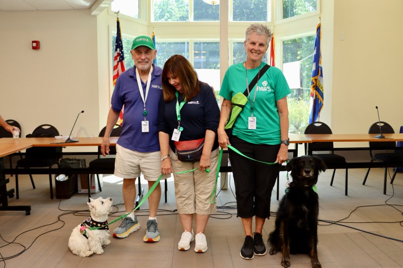Volunteers from PAWS for People brought some of their therapy dogs to the event. Shown are (l-r) Andy Feinberg and Amy Feinberg with their dog Iris and Kathy McGinley with her dog Marley.