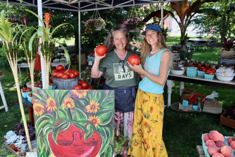 Emily Keyser Gofus, left, and Hallie Keyser of Rays Produce and Flowers in the Brush Factory show off some giant tomatoes they had for sale at the garden market.