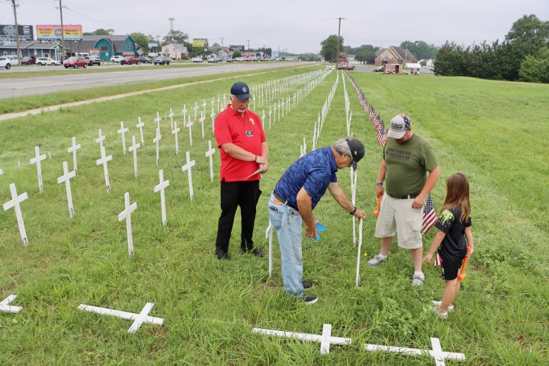 Members of the Knights of Columbus and Irreverent Warriors add 22 more crosses to the field at St. Jude the Apostle Church on Route 1 near Lewes. Shown are (l-r) Chuck Augustine, Knights of Columbus; Mike Beauparlant, Knights of Columbus; Brandon Zeitler, Irreverent Warriors; and Zeitler’s daughter, Emma. BILL SHULL PHOTOS