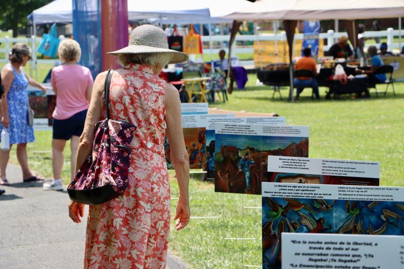 A visitor looks at the story walk along one of the paths in the park. The panels told various chapters of African American history. They were made possible by the Albarran family.