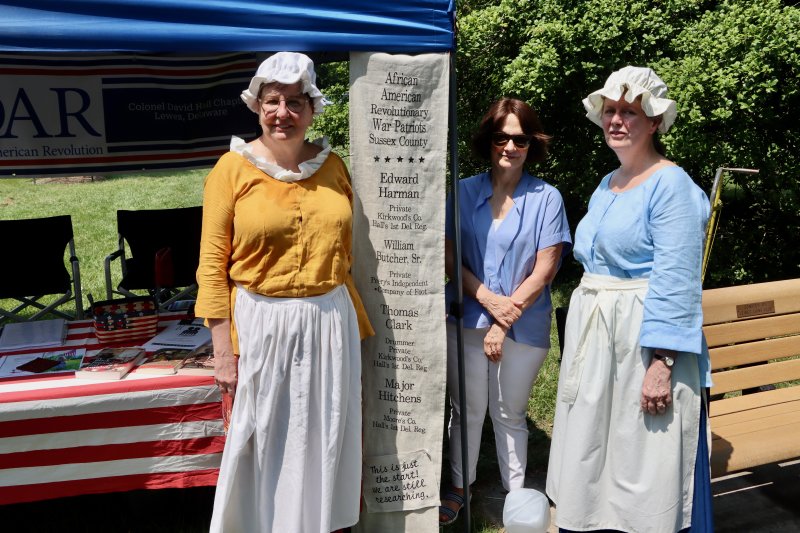 Member of the Daughters of the American Revolution Col. David Hall Chapter stand in front of a banner with the names of four African Americans from Sussex County who fought in the American Revolution. The DAR group is working to identify more African Americans and Native Americans who served in the war. Shown are (l-r) Hilda Adams, Patti Garrison and Amy Kalkbrenner.