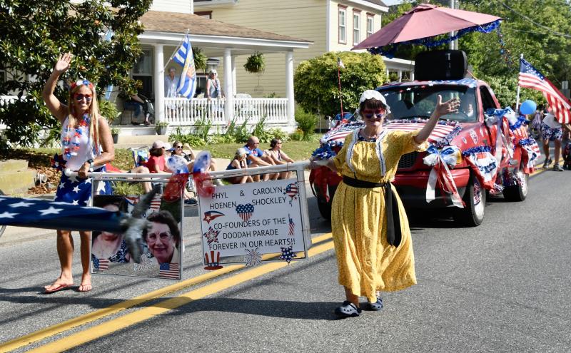 Ashley Tanis, left, and Kathryn Hoenen-Enevold carry a banner in the 2024 Doo-Dah Parade in Lewes in tribute to founders Phyllis Hoenen and Carolyn Shockley. The families have started a fundraising campaign through the Greater Lewes Foundation to get enough money to pay for the parade permit, insurance and tax on their LLC. RON MACARTHUR PHOTO