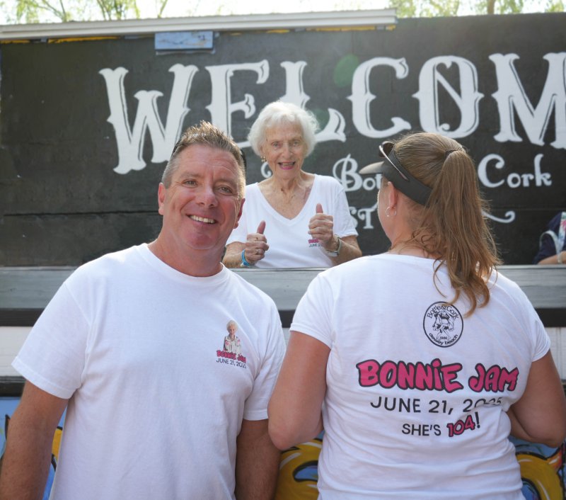 Dewey Beach Mayor Bill Stevens, left, and his wife Janine sport Bonnie Jam T-shirts at the Bottle & Cork’s Bonnie Jam, while Bonnie McCarthy sits in the middle.