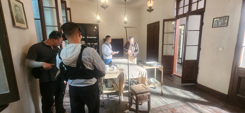 Larry Kelley, right, during filming of a segment in the former hospital in Linhai where Doolittle Raider Ted Lawson had his leg amputated after being injured when he crash landed his plane nearby. Kelley said the table he is standing next to is the actual table where the surgery took place, not a replica.