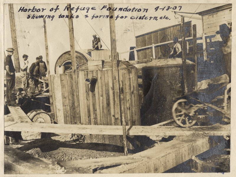 Crews build the original Harbor of Refuge Light in 1907. This photograph shows tanks and forms for the cistern. SOURCE: U.S. LIGHTHOUSE SERVICE