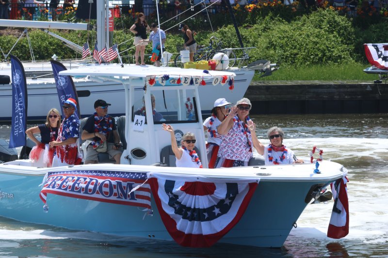 The Freedom Boat Club sponsors the annual boat parade. The folks onboard the Freedom XL wave as they pass by the judges.