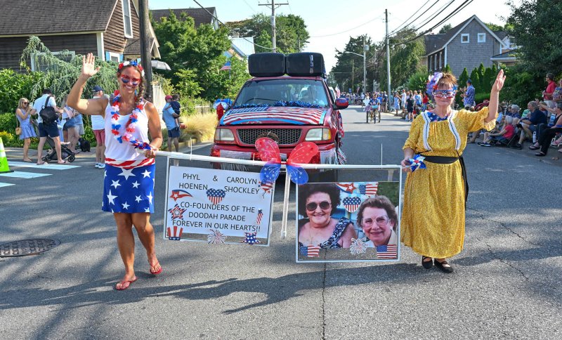 Ashley Hoenen Tanis, Phyllis’ granddaughter, left, and Kathy Hoenen-Enevold, Phyllis’ daughter, carry a banner in memory of the founders of the Doo-Dah Parade, Phyllis Hoenen and Carolyn Shockley.
