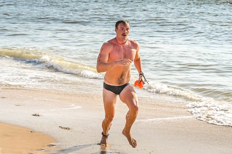 Josh Walker leaves the surf and sprints to the transition area. He placed seventh overall with a time of 32:39.6.