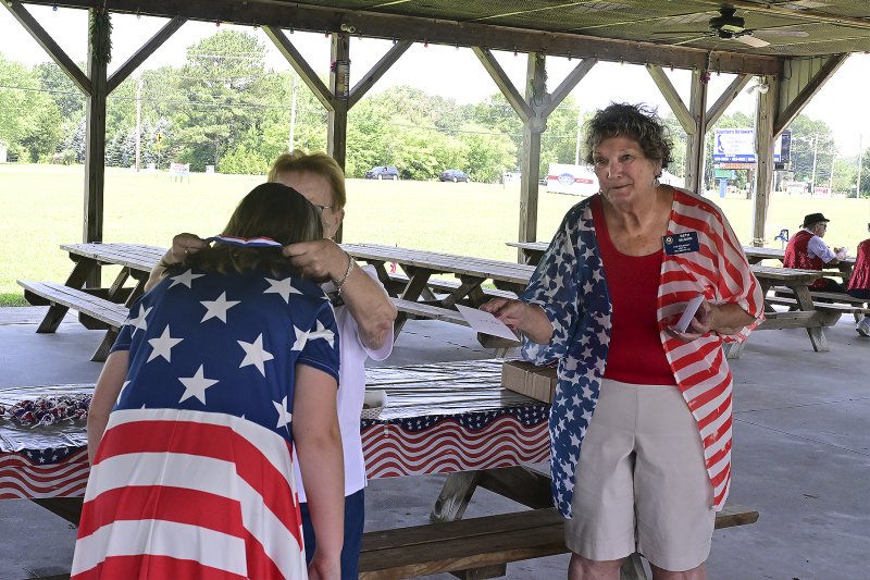 Mackanzie Mood is presented with the second-place ribbon and award for most patriotic attire by June Jones, president of American Legion Auxiliary Unit 28, and Beth McGinn, auxiliary vice president.