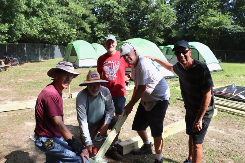 A team of volunteers is building a shade tent for residents. Shown are (l-r) Rick Venish, Ray Waugh, Mike Sipos, Jack Muhs and Frank Arena, Tharros director of governance.