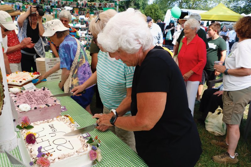 Sally Packard cuts one of the cakes celebrating the HLFM’s 20th birthday. Packard attended the first market 20 years ago.