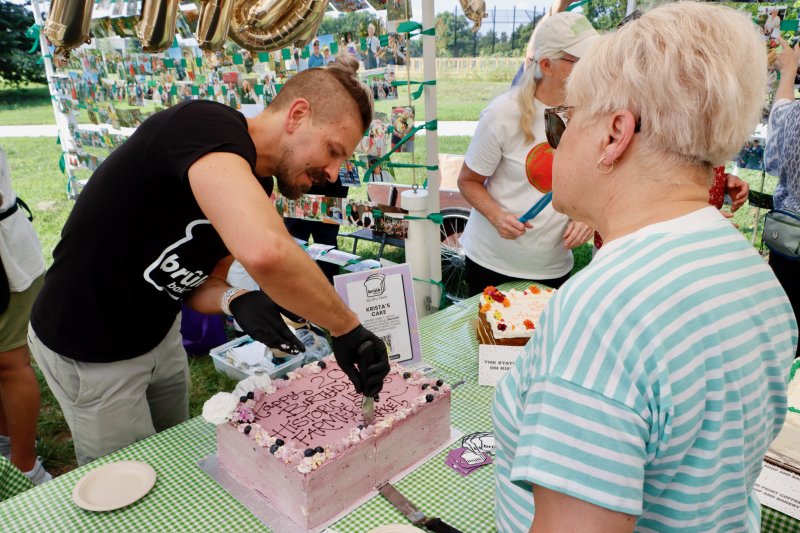 Dru Tevis of Brule Bakery cuts his cake during the HLFM’s celebration. Tevis was one of five vendors who contributed cakes for the celebration.