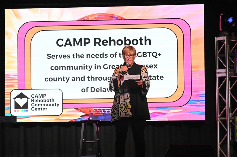 CAMP Rehoboth Executive Director Kim Leisey welcomes the sell-out crowd to the Aug. 30 auction and entertainment.