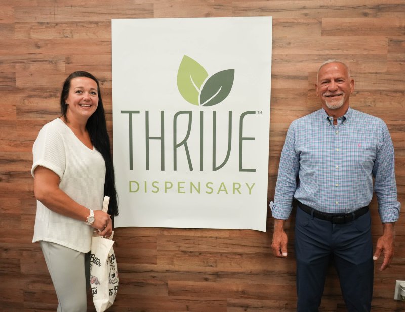 Joyce McCarthy, left, is the first recreational marijuana customer at the Thrive Dispensary near Lewes. She holds her product with Mark Lally, the company’s vice president of governmental affairs and the former president and CEO of First State Compassion.