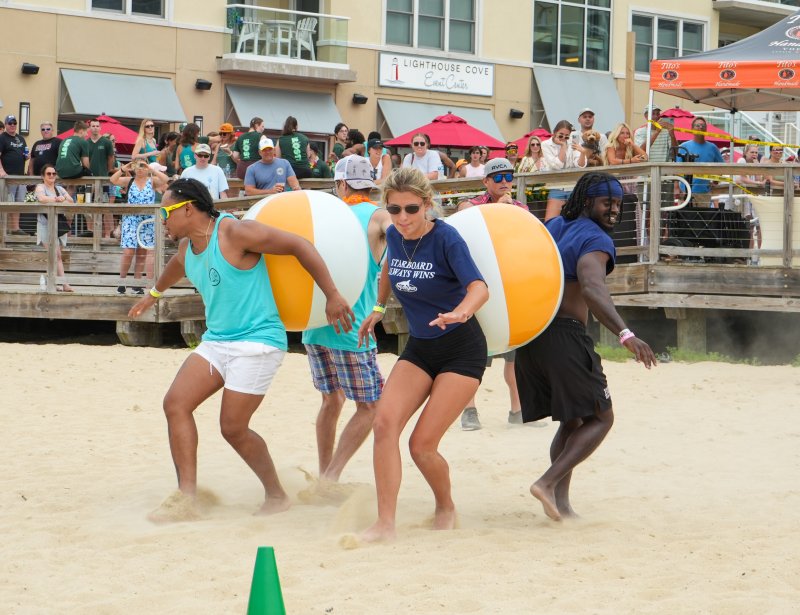The Starboard’s Izzy Friedrich and Terrique Riddick race against Rehoboth Ale House team members during the beach ball relay.