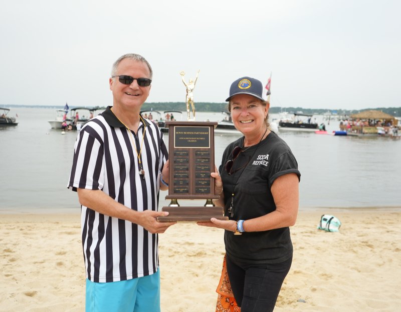 Referees Ken Garfinkel and Elisabeth Gibbings, a Dewey Beach commissioner, hold up the Dewey Business Partnership Restaurant Games trophy.