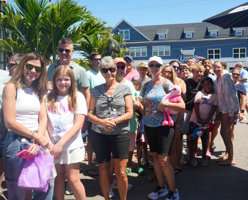 A group waits in line for one of the punch boards at SeeShore Fest. Shown are (l-r) Christine Sutton, Zoe Sutton, Ed Sutton, Jerry Myers, Ruth Walsh, Scott Pierce, Fletcher Hauck, Emmett Pierce, Debbie Jensen, Jaime Carter-Hauck, Dax Napolitano, Luke Depanfilis, Isaac Nyandusi, Griffin Nyandusi and London Steigerwalt.