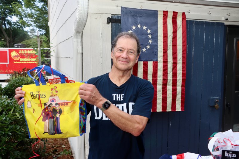 British Invasion Night is the brainchild of Michael Whitehouse, shown holding a Yellow Submarine bag that was among the raffle items at the fundraiser.