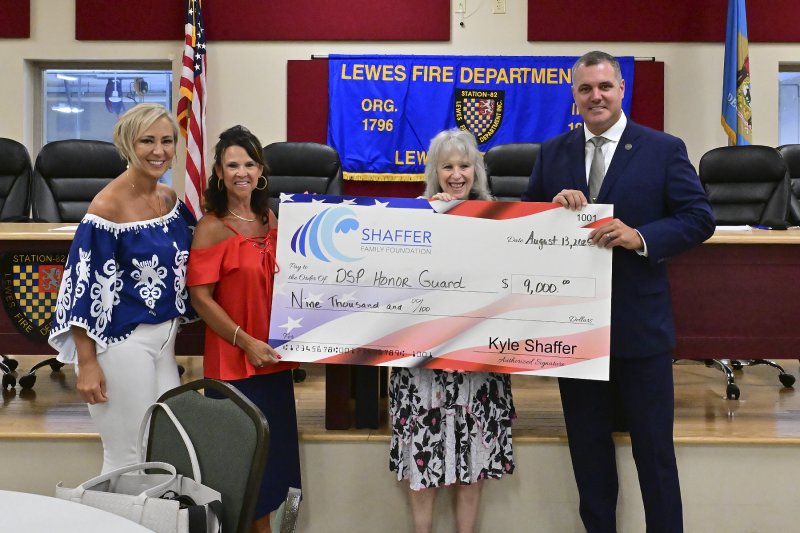 Rally for Our First Responders board members (l-r) AnnMarie Truszcienski, Kyle Shaffer and Joyce Bachner present Delaware State Police Capt. Jeffrey Whitmarsh with a check.