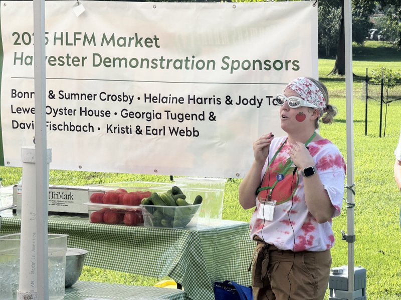 Becca Seeley, office manager for the Historic Lewes Farmers Market, introduces Chef Bill Clifton at the demonstration tent. Seeley is certainly dressed for the occasion.