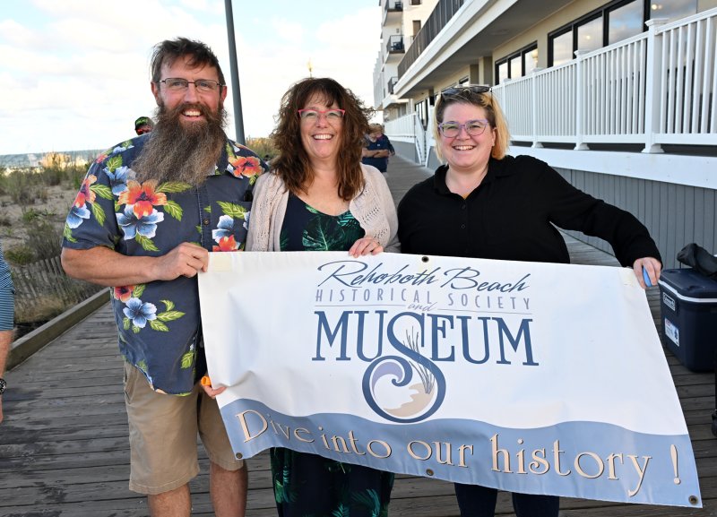 Holding the Rehoboth Beach Historical Society and Museum banner are (l-r) Dan Pope, Bonnie Golden and Madeline Golden.