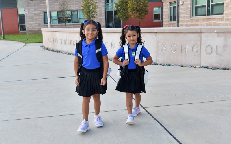 Heven Garcia Paz, 7, left, and her sister Brithany, 5, are the first students to arrive at the opening day of the 2025 year at H.O.B. Elementary School. DAN COOK PHOTO