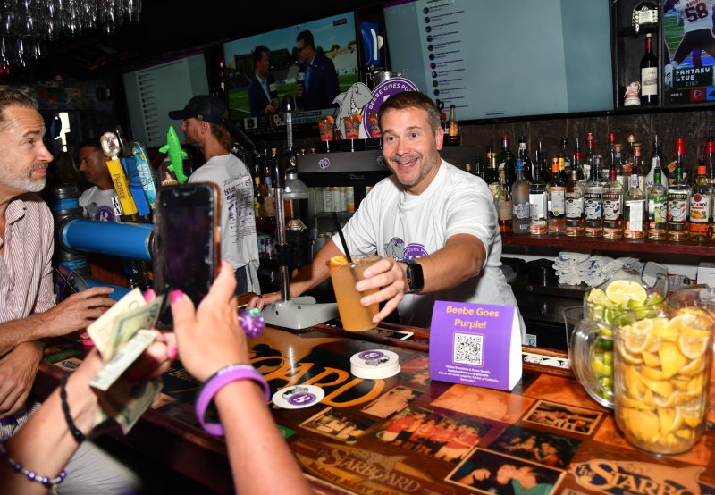A customer takes a pic of guest bartender Dr. Bill Chasanov.