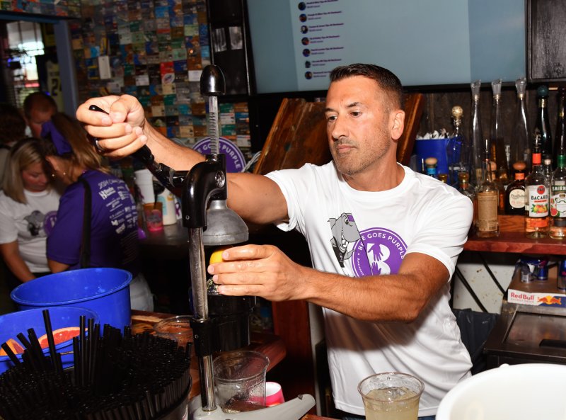 CAMP Rehoboth board member and guest bartender Mike DeFlavia squeezes oranges for a crush.