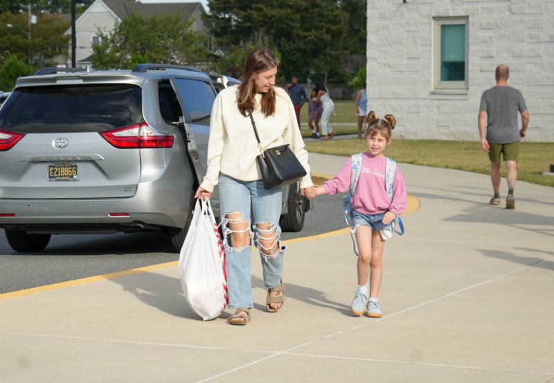 Emilie Rhodes holds her daughter Ava’s hand as they walk to the front door of Rehoboth Elementary for Ava’s first day of first grade. ELLEN MCINTYRE PHOTO