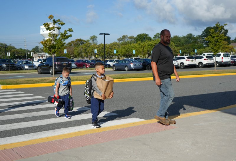 Students get ready to enter Rehoboth Elementary with their school supplies. Shown are (l-r) first-grader Mason Dixon, second-grader MJ Ridgeway and Chris Dixon. ELLEN MCINTYRE PHOTO