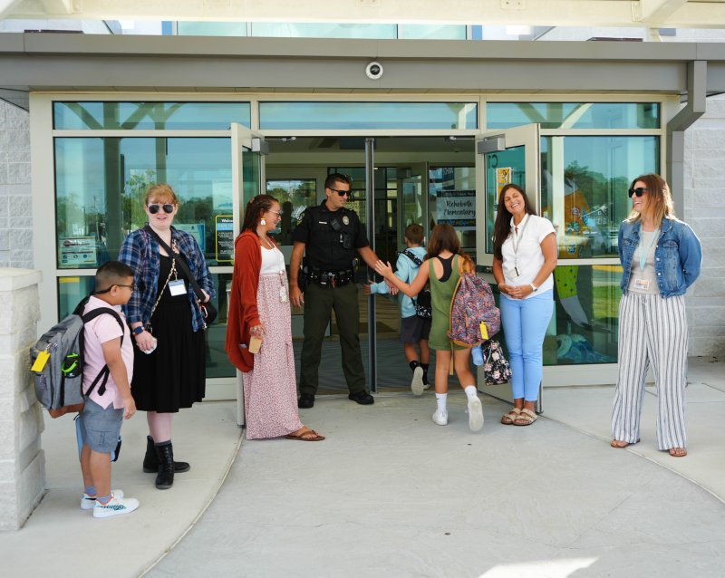 Students are greeted with smiles and high fives as they walk into Rehoboth Elementary on their first day of school. Faculty members shown are (l-r) Faith Palmer, Taylor Phillips, Rehoboth Police officer and student resource officer Rob Scisco, Christina Solloway and Amber Rittenhouse. ELLEN MCINTYRE PHOTO